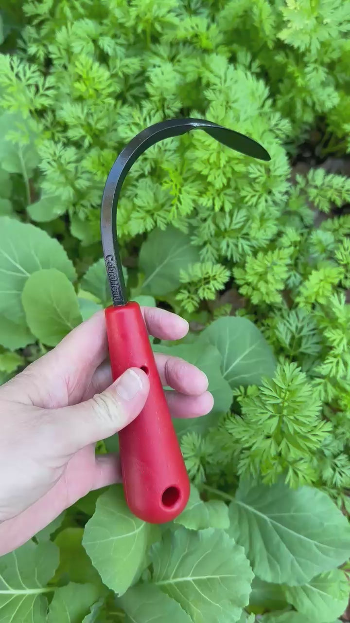 Red-handled CobraHead Mini Garden tool shown from different angles with leafy green plants in the background
